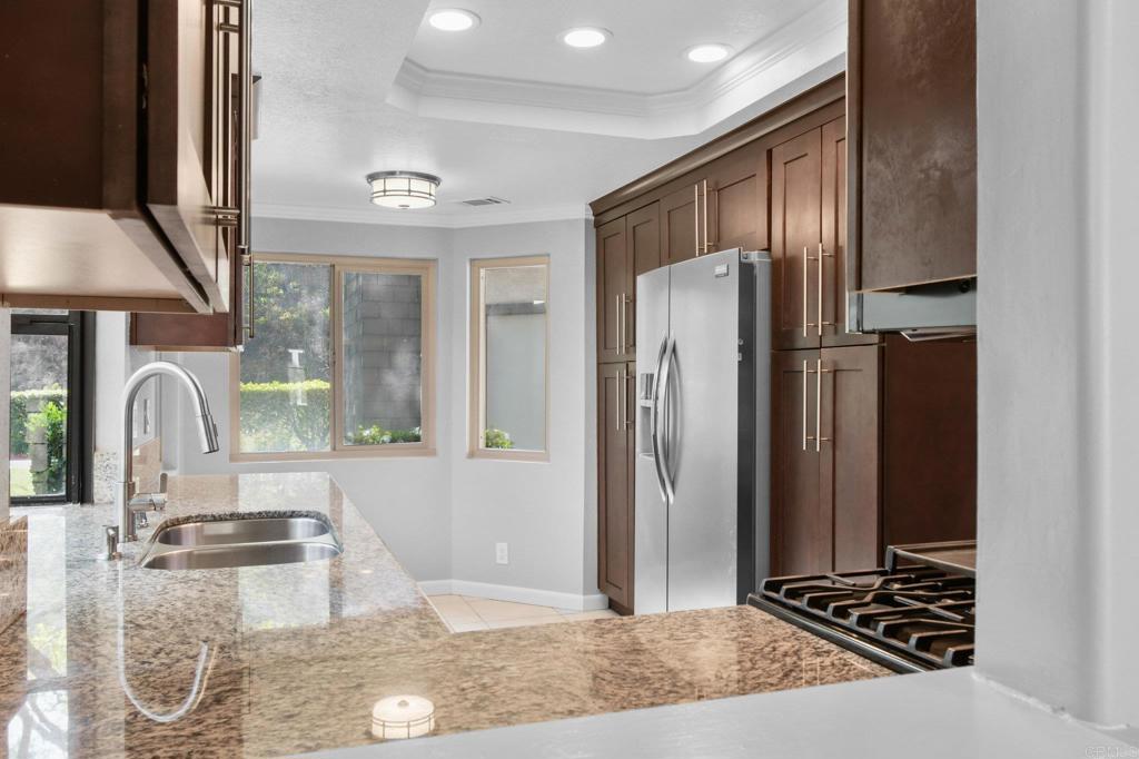 5667 Adobe Falls Road, Unit C San Diego, CA 92120 - Photo 13 of 40 a kitchen with stainless steel appliances granite countertop a refrigerator and a sink