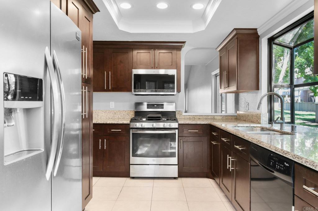 5667 Adobe Falls Road, Unit C San Diego, CA 92120 - Photo 16 of 40 a kitchen with stainless steel appliances granite countertop a stove a sink and a refrigerator