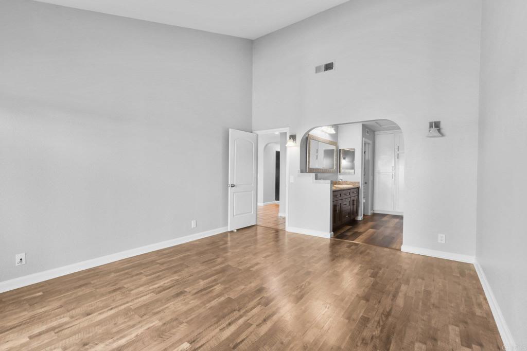5667 Adobe Falls Road, Unit C San Diego, CA 92120 - Photo 21 of 40 a view of a kitchen with refrigerator and wooden floor