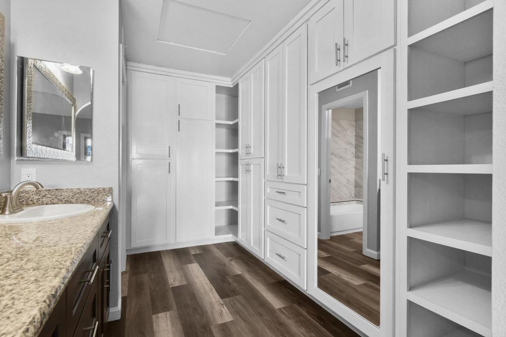 5667 Adobe Falls Road, Unit C San Diego, CA 92120 - Photo 24 of 40 a bathroom with a granite countertop sink mirror and vanity