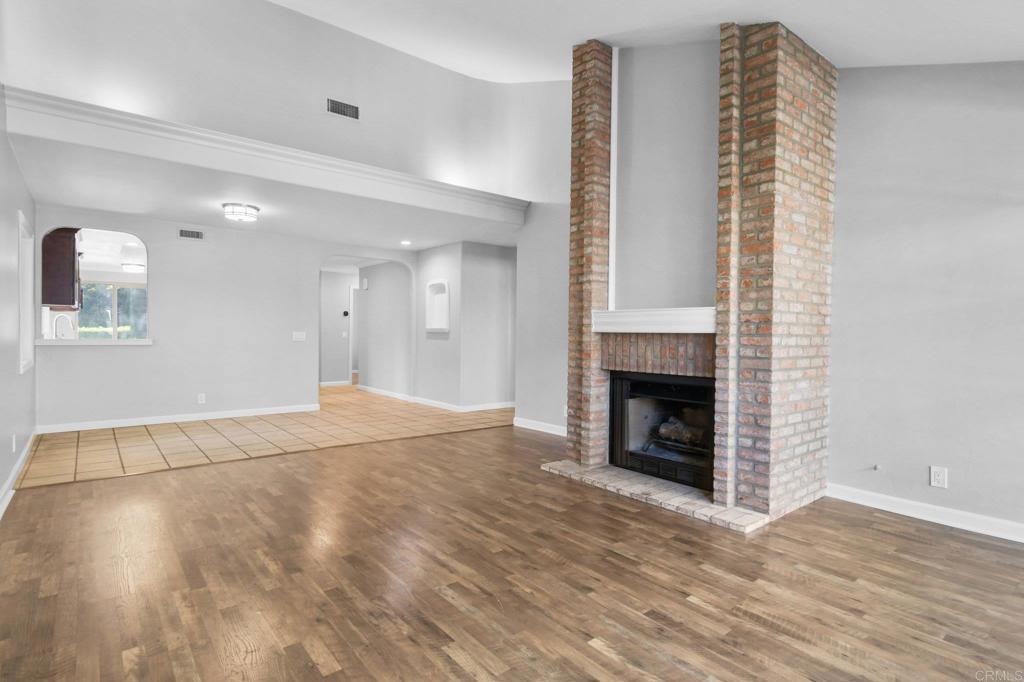 5667 Adobe Falls Road, Unit C San Diego, CA 92120 - Photo 10 of 40 a view of an empty room with wooden floor fireplace and a window