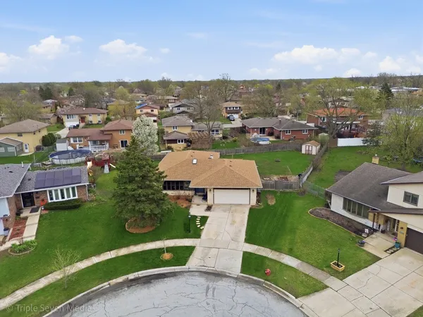 an aerial view of a house with outdoor space and a garden
