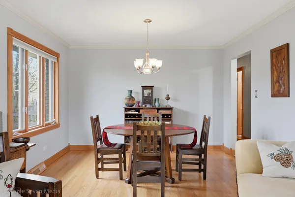 a living room with furniture and a dining table with wooden floor