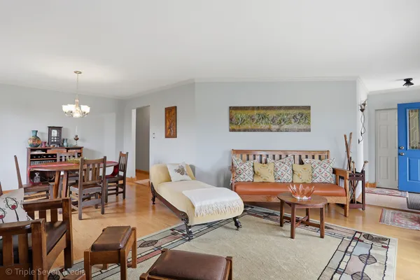 a view of a dining room with furniture a chandelier and wooden floor