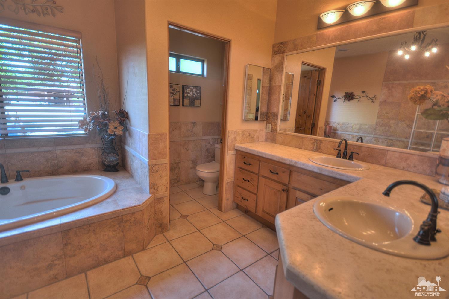 39825 Berenda Road Temecula, CA 92591 - Photo 31 of 54 a spacious bathroom with a granite countertop sink and a mirror