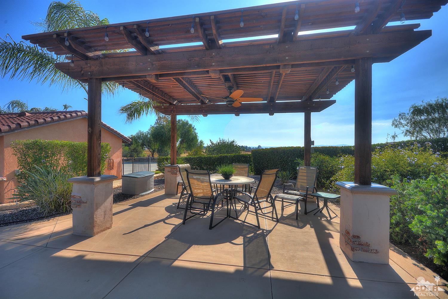 39825 Berenda Road Temecula, CA 92591 - Photo 36 of 54 a view of a patio with table and chairs potted plants with palm trees