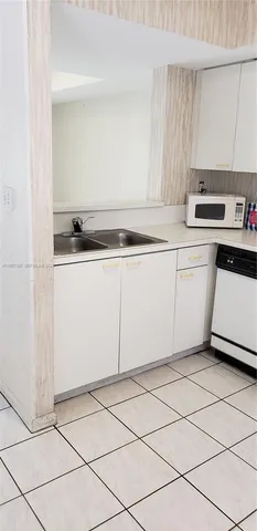 a kitchen with granite countertop cabinets a sink and a stove with a dining table