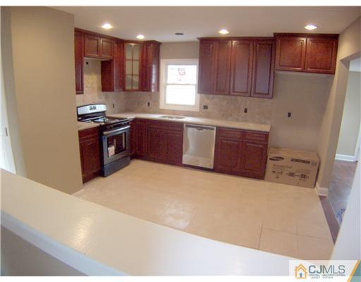 76 Middle Hill Road Colonia, NJ 07067 - Photo 4 of 12 a kitchen with stainless steel appliances kitchen island granite countertop a stove a sink and a refrigerator