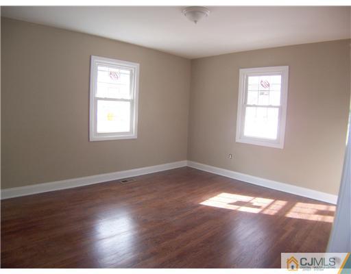 76 Middle Hill Road Colonia, NJ 07067 - Photo 9 of 12 an empty room with wooden floor and windows