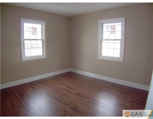76 Middle Hill Road Colonia, NJ 07067 - Photo 10 of 12 an empty room with wooden floor and windows