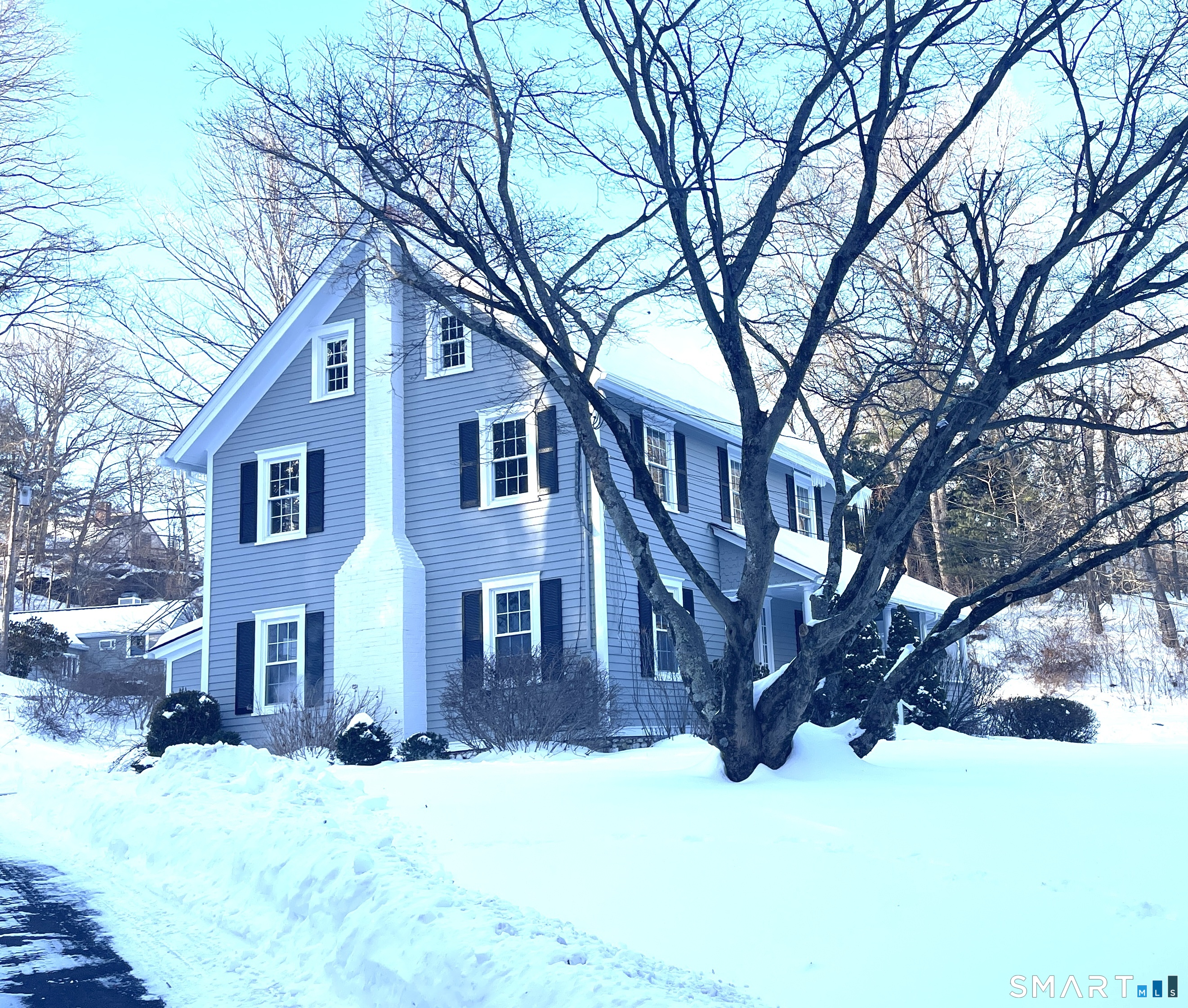 a front view of a house with a yard covered in snow