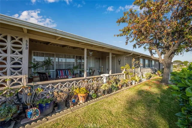front view of a house with a large window and potted plants
