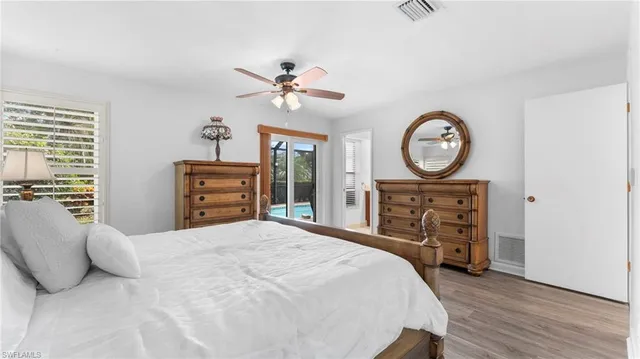 a bedroom with a bed a dresser and chair