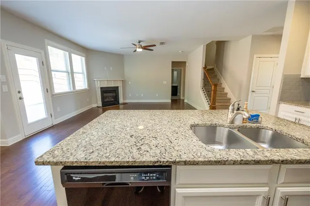 a kitchen with granite countertop a sink and a wooden floor
