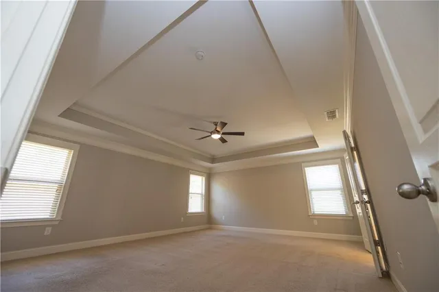 an empty room with window and ceiling fan
