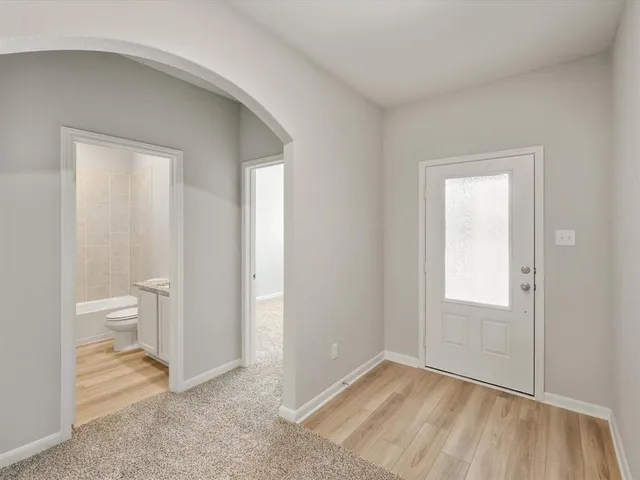 a view of an empty room with a bathroom and a toilet