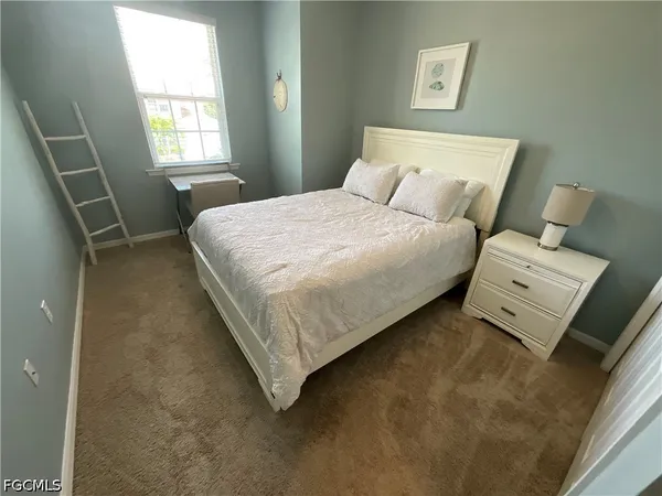 a bed sitting in a bedroom next to a window