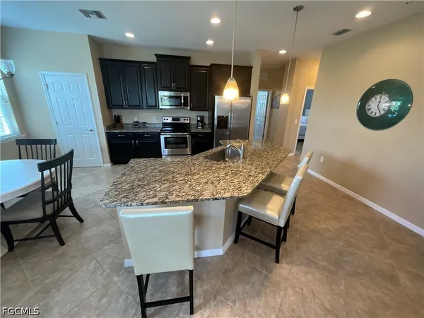 a kitchen with a table chairs refrigerator and microwave