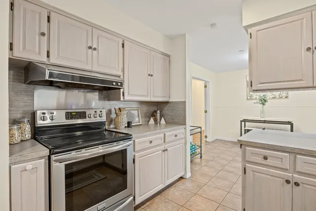 a kitchen with white cabinets and appliances