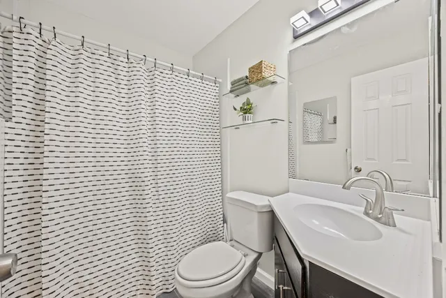 a white toilet sitting next to a bathroom sink