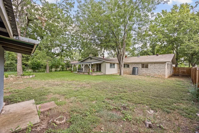 a front view of a house with a garden and trees