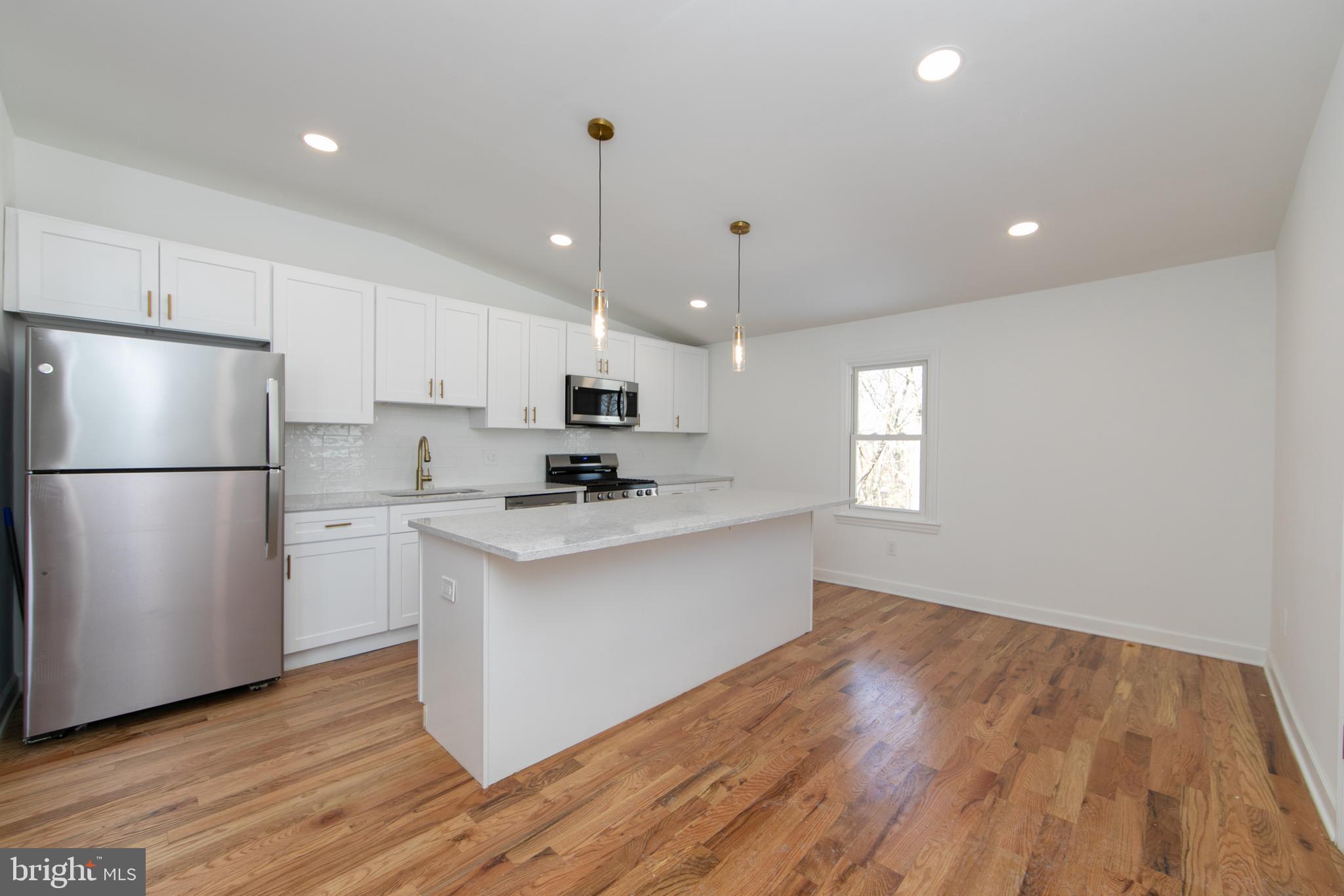 117 West Nicholson Road Audubon, NJ 08106 - Photo 5 of 32 a kitchen with stainless steel appliances granite countertop a refrigerator a sink dishwasher a stove and white cabinets with wooden floor