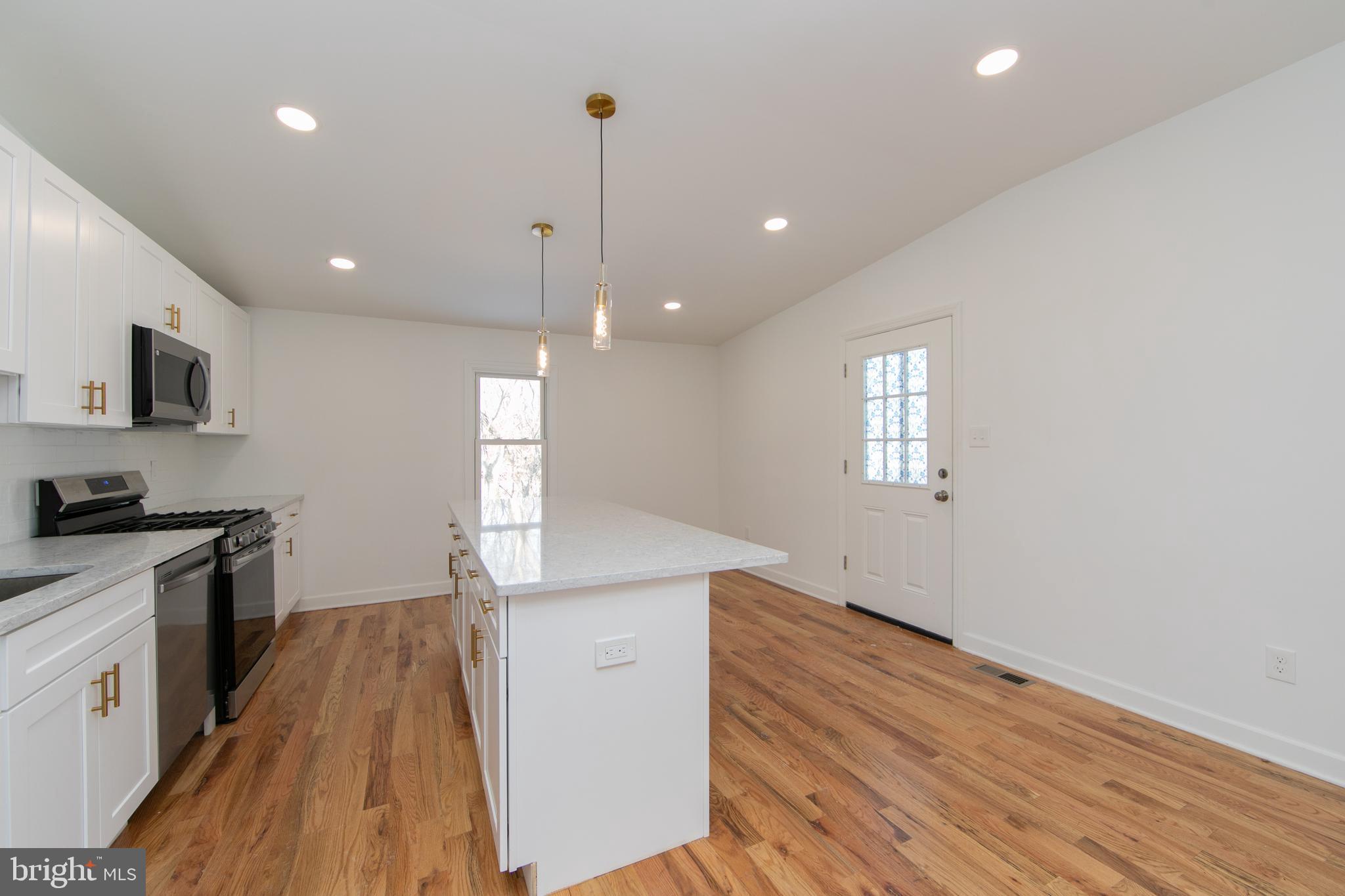 117 West Nicholson Road Audubon, NJ 08106 - Photo 6 of 32 a kitchen with granite countertop a stove and a wooden floor