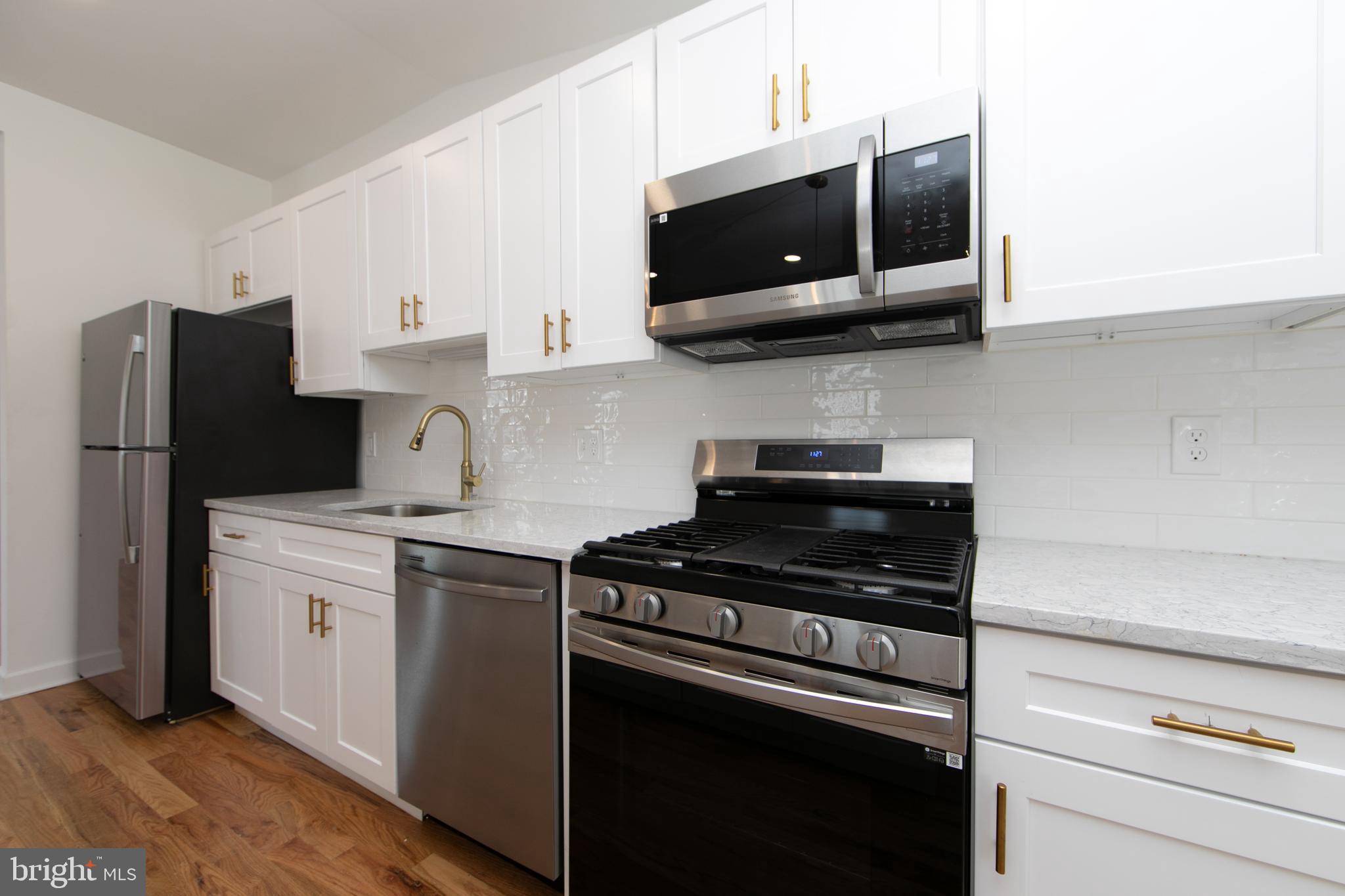 117 West Nicholson Road Audubon, NJ 08106 - Photo 10 of 32 a kitchen with cabinets stainless steel appliances and wooden floor