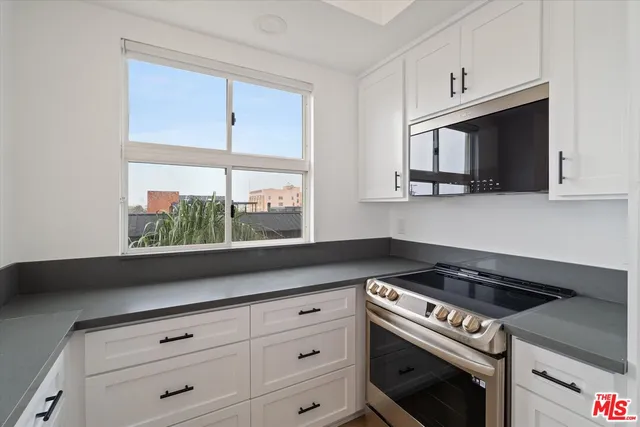 a kitchen with white cabinets and appliances