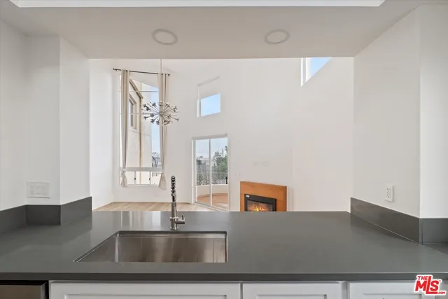 a kitchen with kitchen island a sink stainless steel appliances and a counter top space
