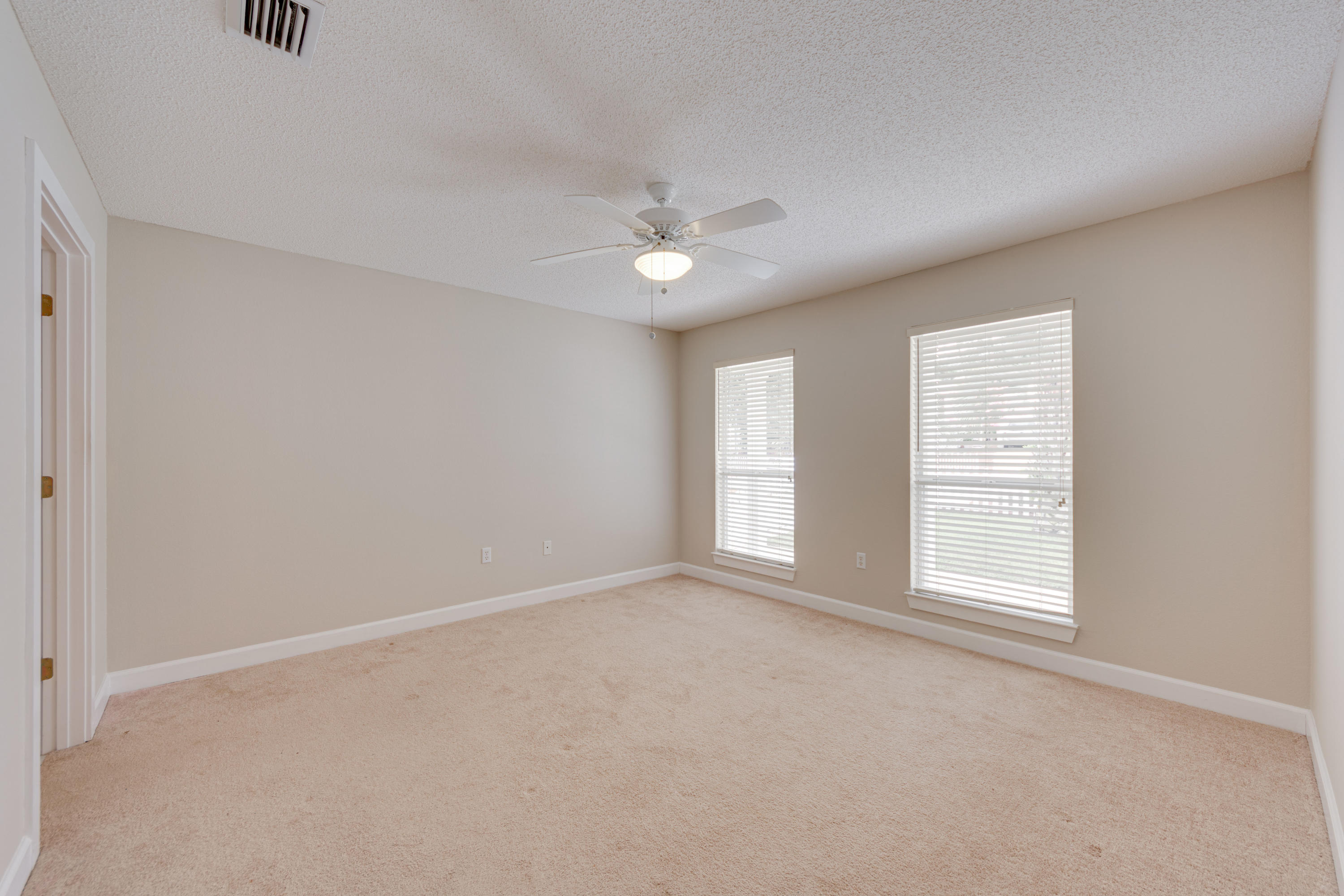135 Gulfwinds Way Santa Rosa Beach, FL 32459 - Photo 15 of 51 an empty room with chandelier fan and windows