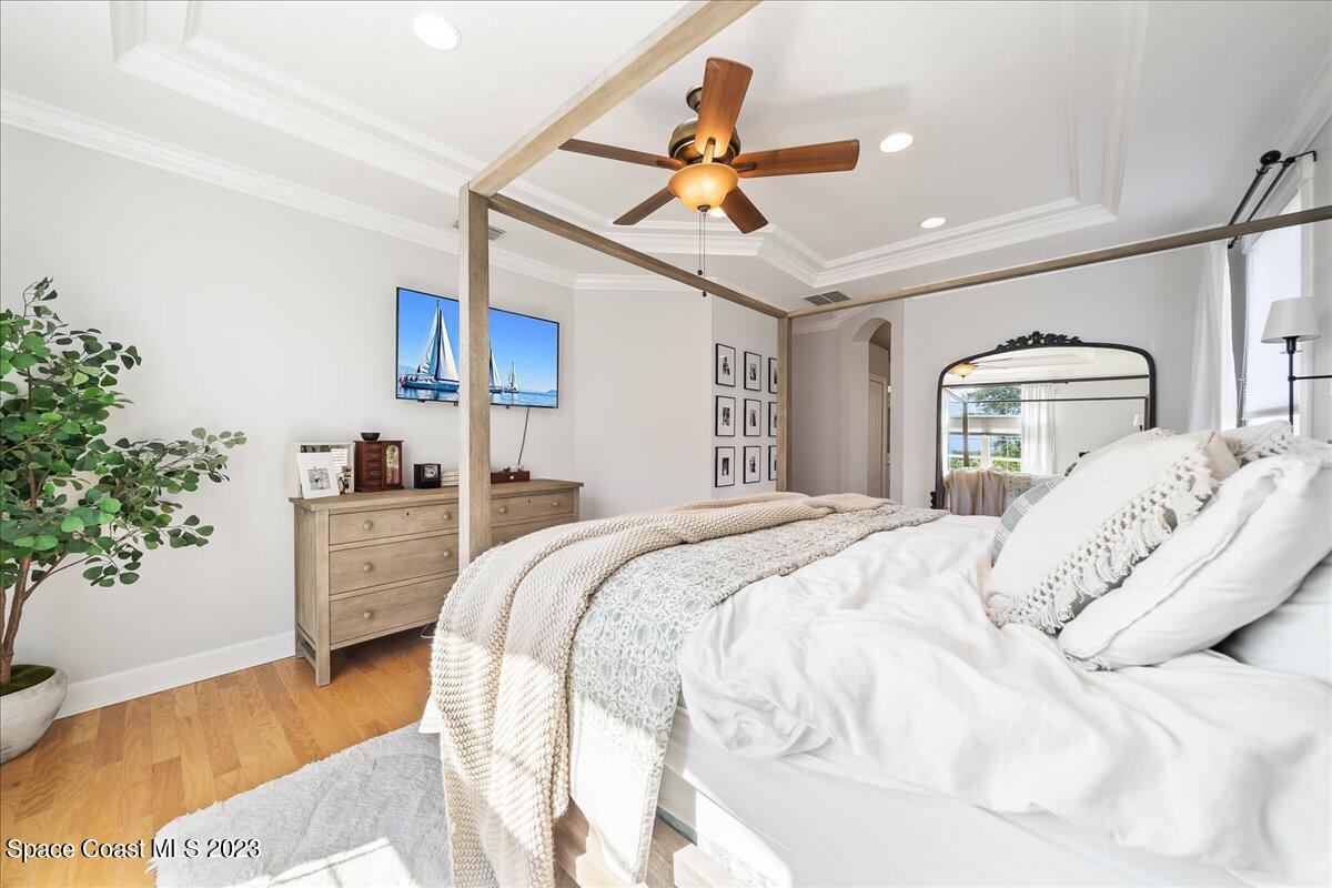 250 Baytree Drive Melbourne, FL 32940 - Photo 27 of 61 a bedroom with a large bed and a chandelier