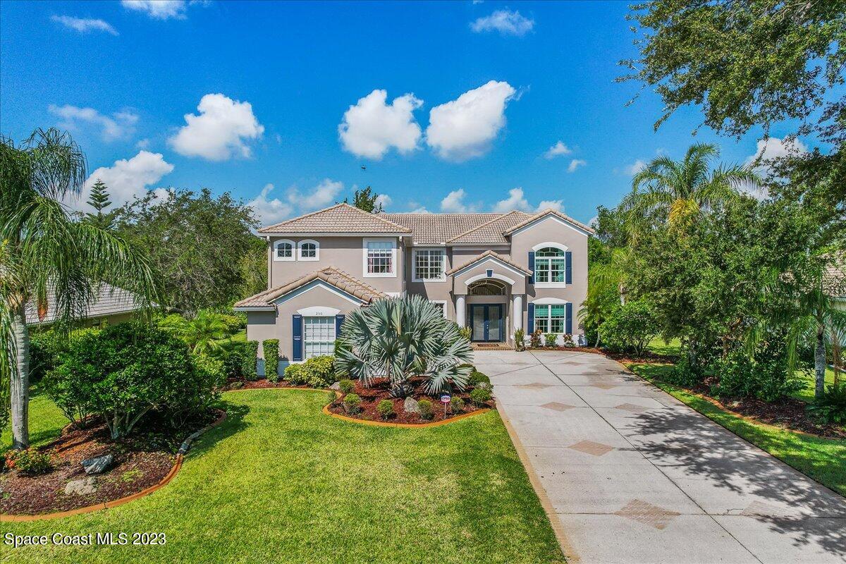 250 Baytree Drive Melbourne, FL 32940 - Photo 50 of 61 a front view of a house with a yard and potted plants