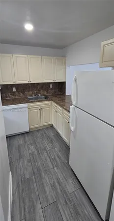 a kitchen with a refrigerator and a stove top oven