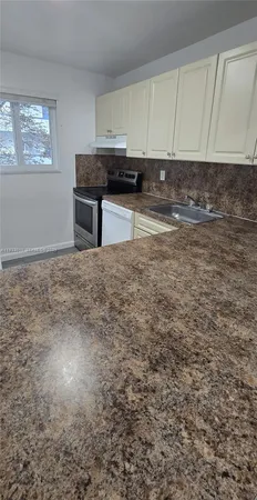 a view of kitchen with cabinets and a stove top oven