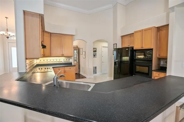 a view of a kitchen with stainless steel appliances granite countertop a refrigerator and a sink