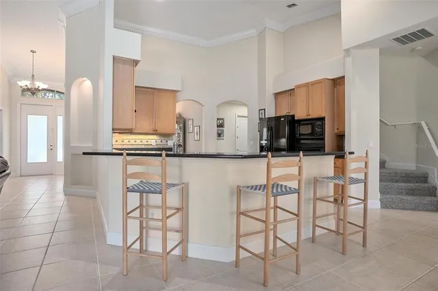 a kitchen with stainless steel appliances kitchen island granite countertop a refrigerator and cabinets