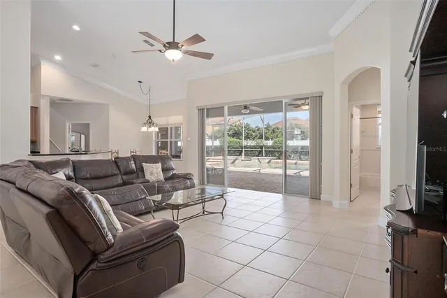 a living room with furniture a flat screen tv and a large window
