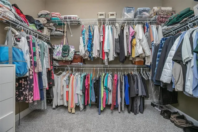 a view of walk in closet with clothes