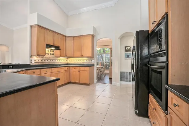 a kitchen with stainless steel appliances granite countertop a refrigerator a sink a stove and island