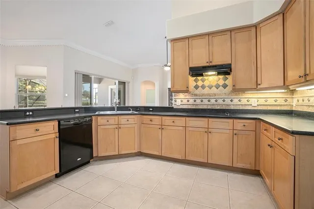 a kitchen with stainless steel appliances granite countertop a sink and dishwasher a stove top oven with white cabinets