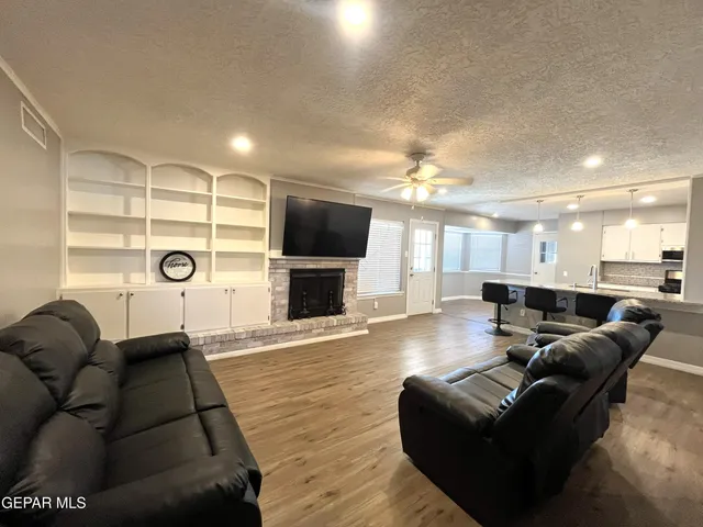 a living room with furniture a flat screen tv and a fireplace