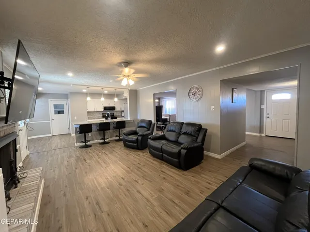 a living room with furniture a flat screen tv and a fireplace