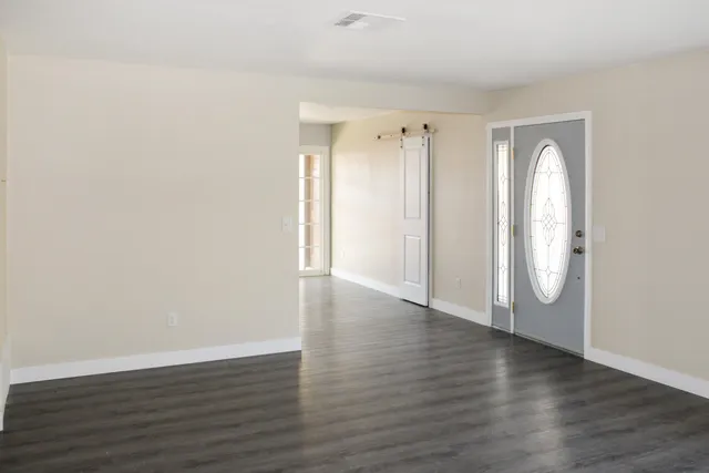 a view of a room with wooden floor and window