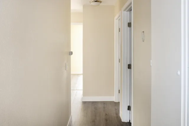 a view of a hallway with wooden floor