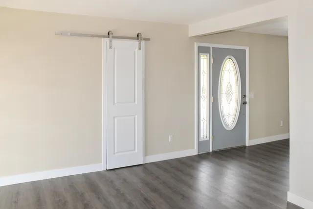 an empty room with wooden floor and window