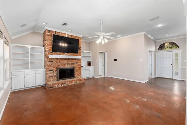 a view of an empty room with a fireplace and a window
