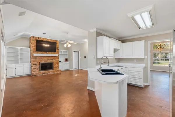 a view of a kitchen with a sink a microwave and cabinets