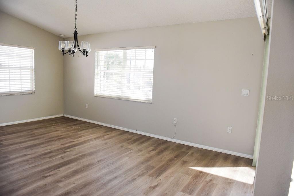 4819 West Raintree Bradenton, FL 34203 - Photo 26 of 37 an empty room with wooden floor ceiling fan and windows