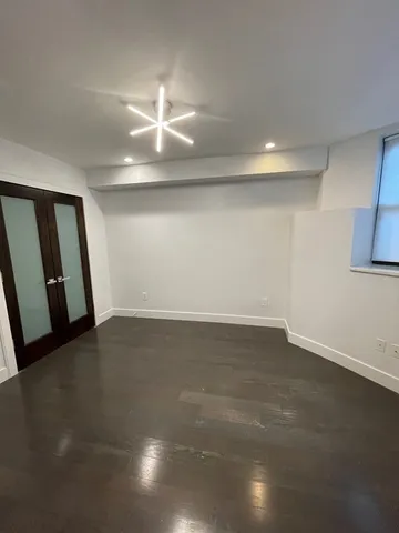 an empty room with staircase and fan